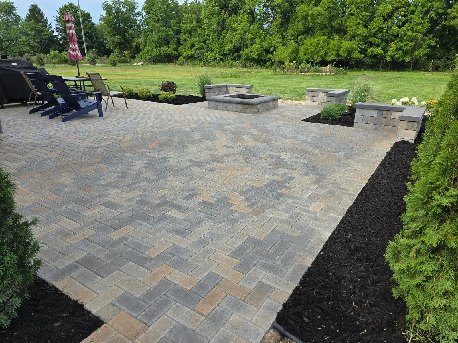 Freshly installed paver patio and mulch bed on a Milan commercial property